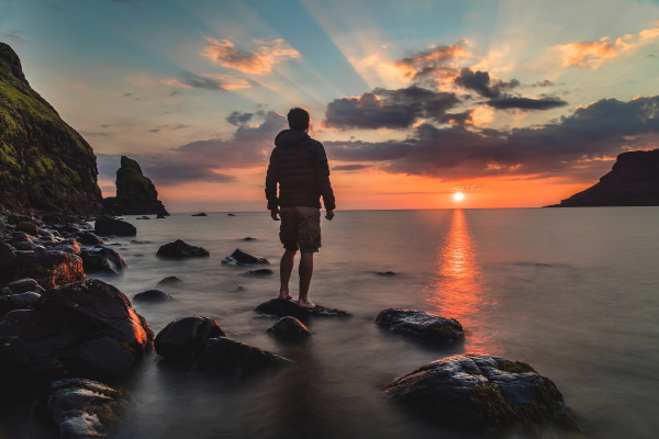 Mann im Sonnenuntergang am Meeer